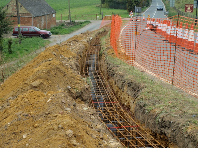 trench for new ground beam with reinforcing rods positioned awaiting concrete